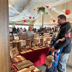 Vendor selling hand-made wooden objects like cutting boards