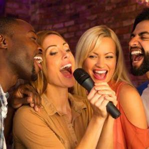 four people singing karaoke in a microphone