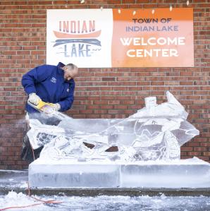 Man carving a snowmobile out of ice