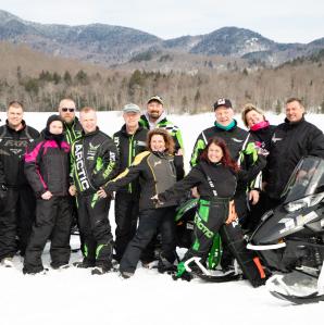 a group of snowmobilers pose for a photo