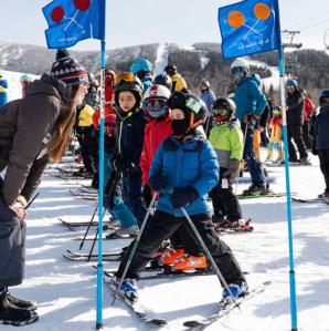 Kids lined up at the starting point of a kids downhill skiing race