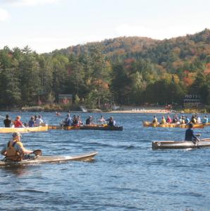 several long boats off the shore of long lake beach paddling in the long boat regatta