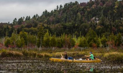 A C2 canoe in a shallow river in the fall