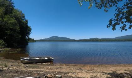 A sandy beach with mountains across the water