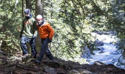 Two males hiking with Auger Falls' spring run behind them