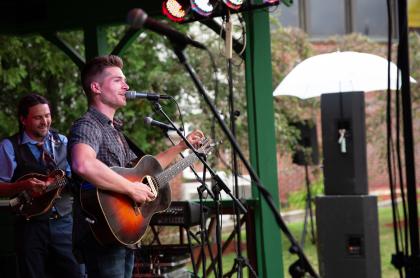 Outdoor live music with man playing guitar and singing