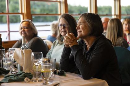 Three women sitting at a table on the WW Durant with glasses of wine in front of them having a good time.