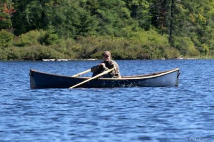 person in canoe with binoculars in hand 