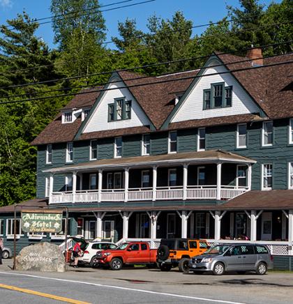 Green and white exterior of Adirondack Hotel on Long Lake
