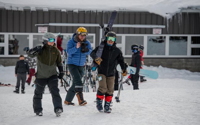 A group of skiers head out onto a ski slope.