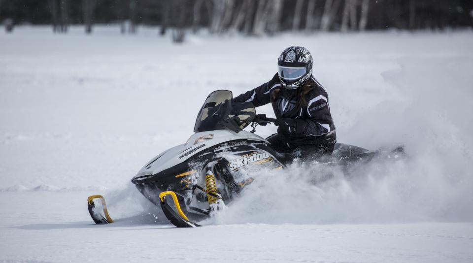 A snowmobiler drifting in the snow.