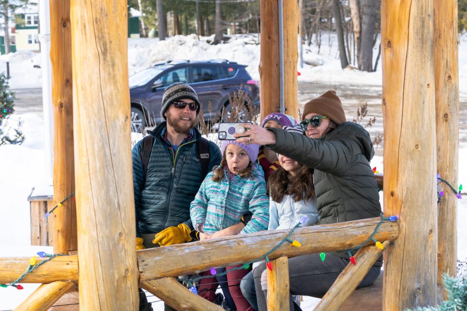 A family taking a selfie in the winter in a wooden gazebo