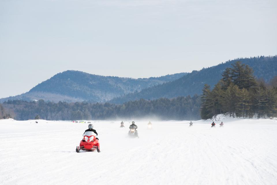 A group of snowmobilers riding across Indian Lake in Hamilton County.