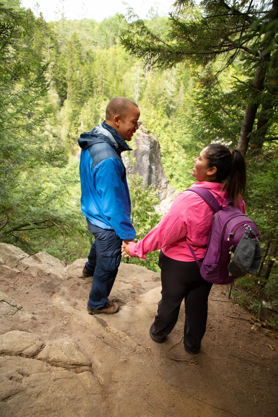 A man and woman look through the branches to O.K. Slip Falls.