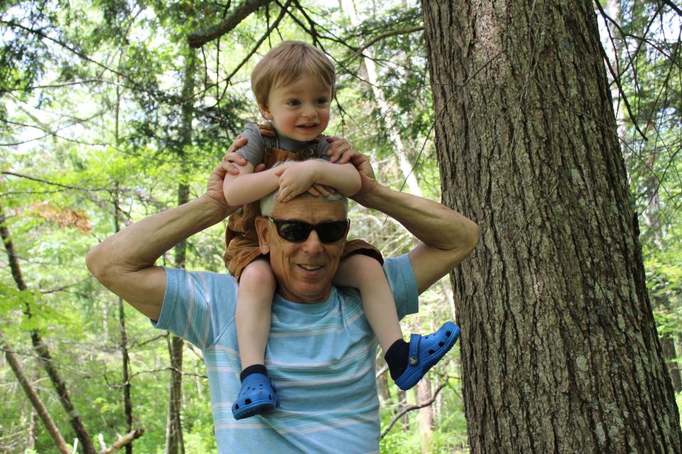 a man holds a child on his shoulders.