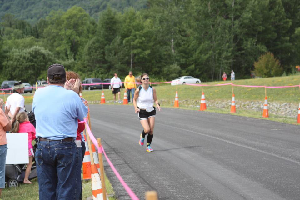 a crowd cheers on a runner.