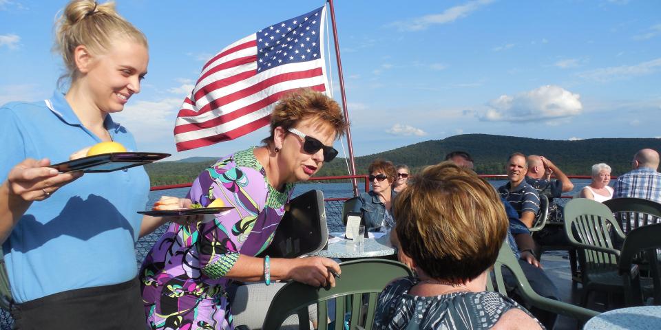 Two women engage in conversation as another woman serves appetizers