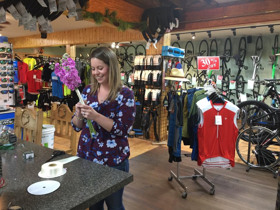 Pedals & Petals employee working on a bouquet for a wedding the next day