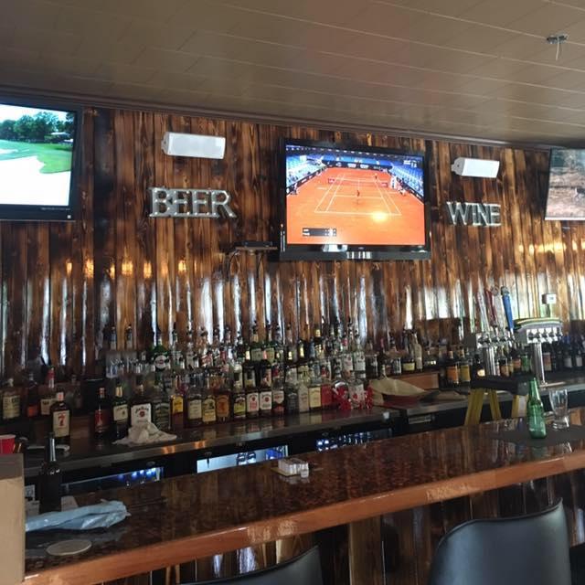 A bar with bottles along a wood wall.