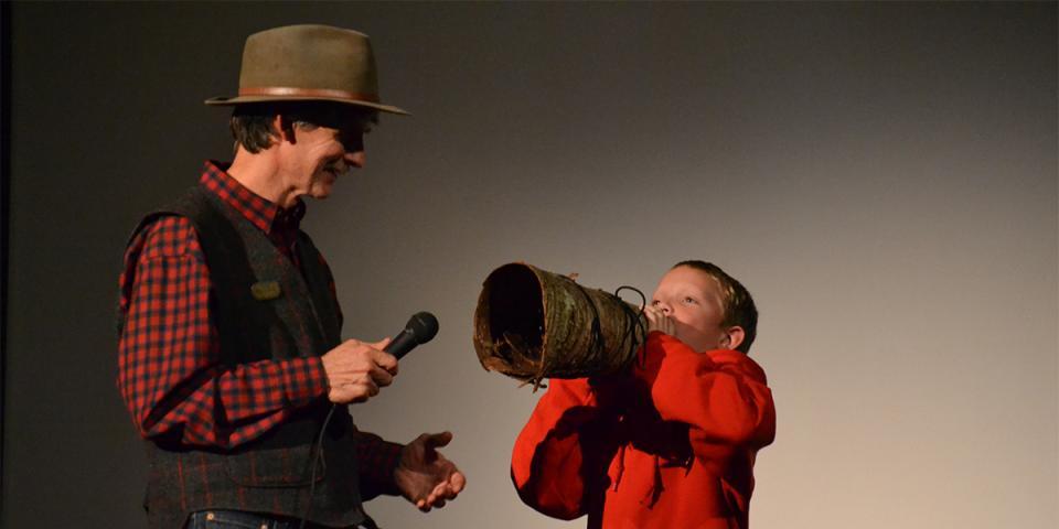 A young child giving his best moose impression and moose call