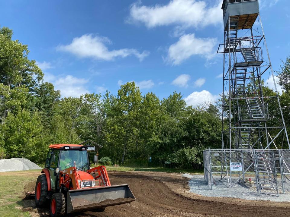 Construction equipment under a steel fire tower in a park