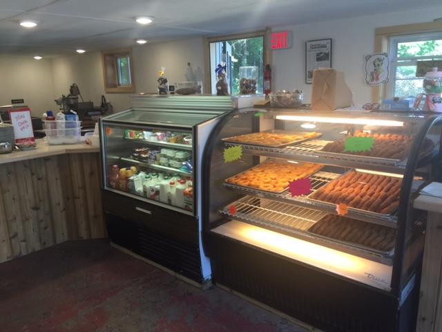 Glass display cases in a shop display freshly-baked donuts and other treats.