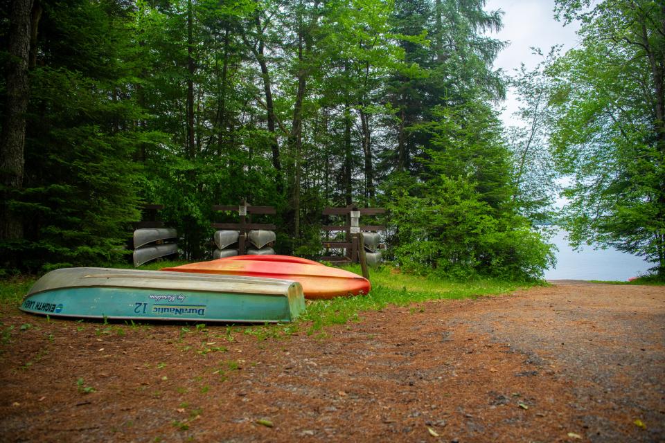 Boats stacked up near an earth ramp for water access