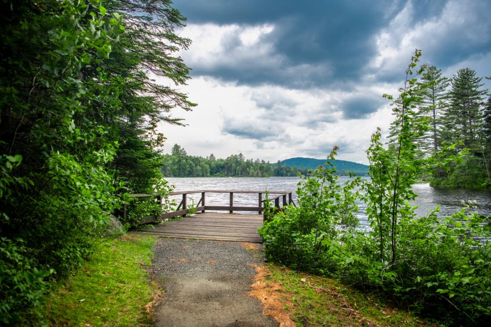 A large deck by the water with dark clouds