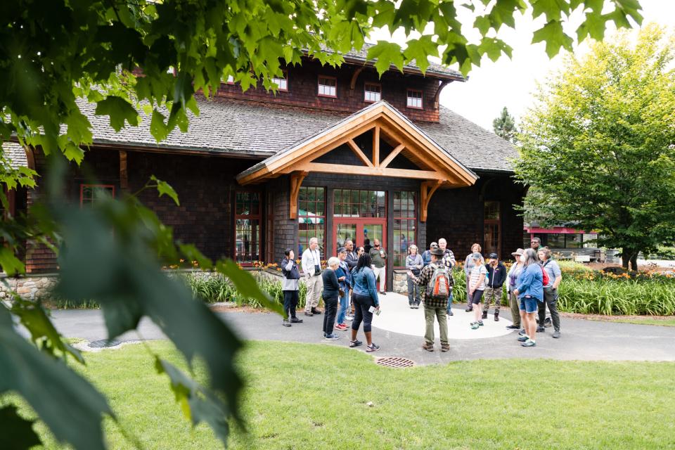 A group stands in front of the Adirondack Experience.