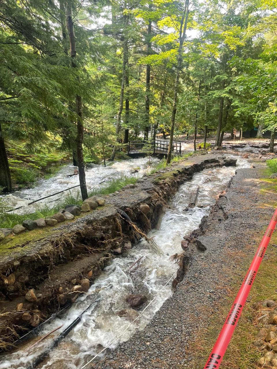 A road with a flooded river running down the center.