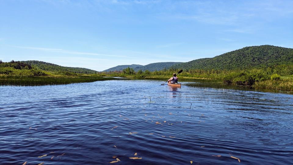 Woman in canoe looking at expansive mountain views