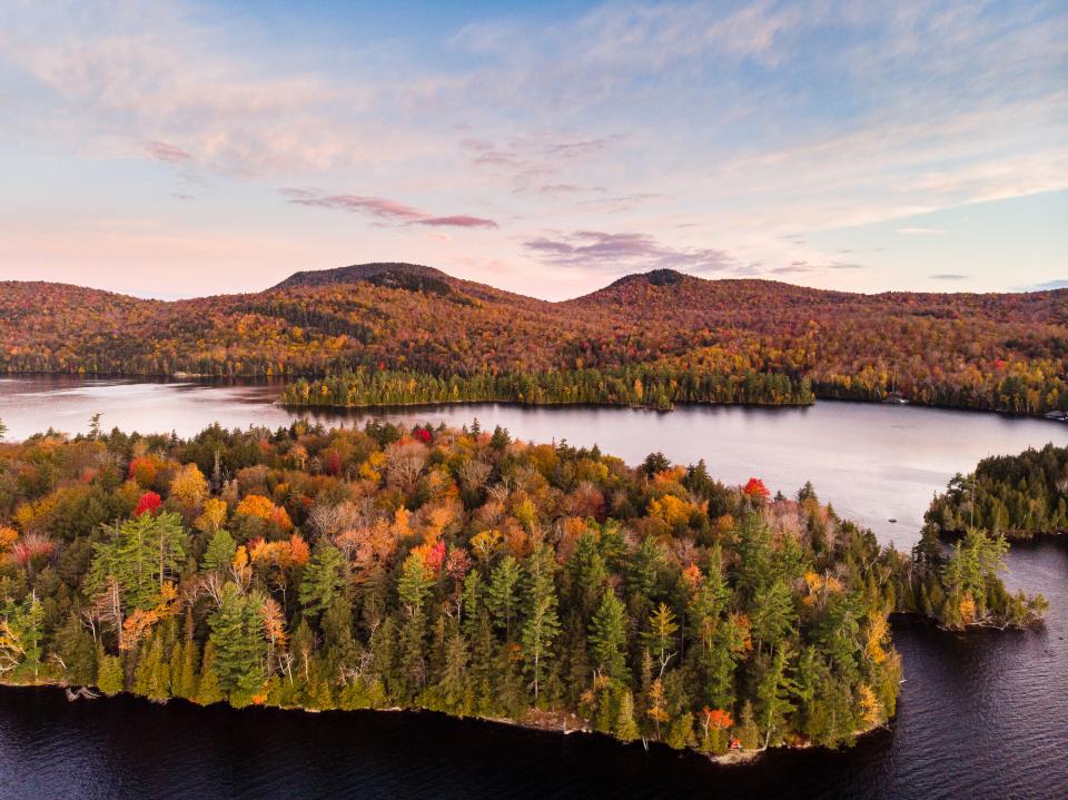 A lake with islands surrounded by fall foliage.