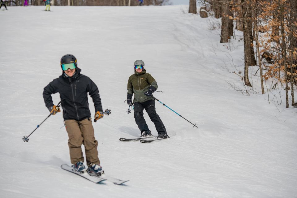 2 downhill skiers coming down the trail at Oak Mountain