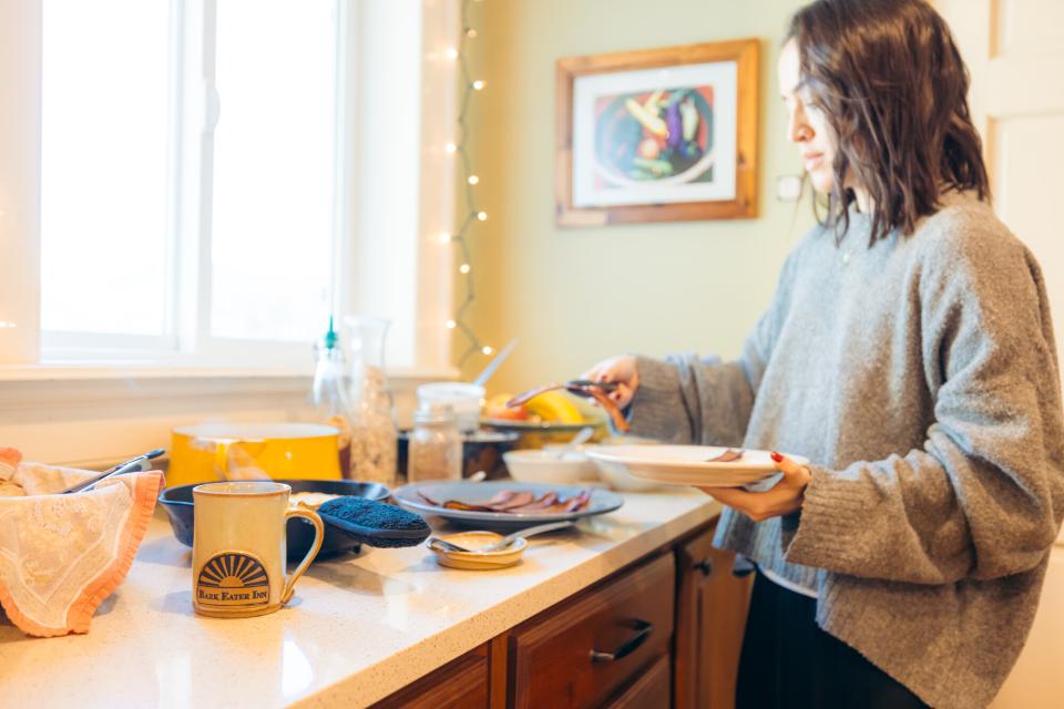 A woman serves herself breakfast.