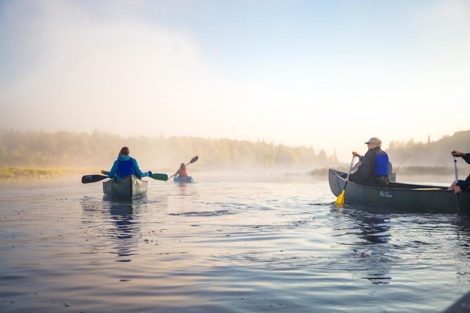 A group of people canoe on a lake.