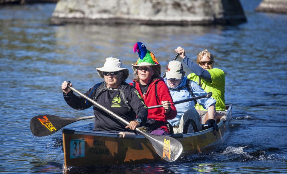 group of four paddlers in a boat, ready to row