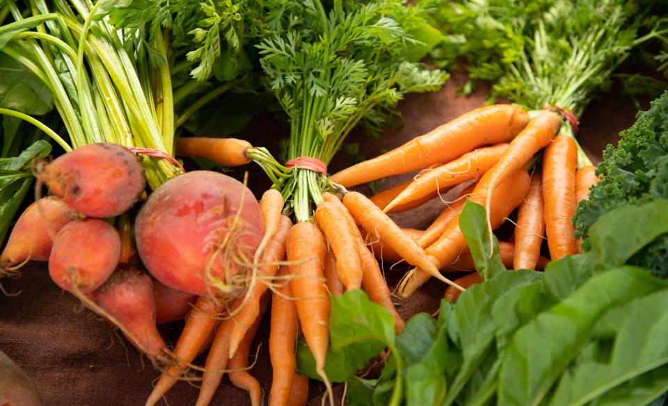 A table of carrots, greens, and other vegetables