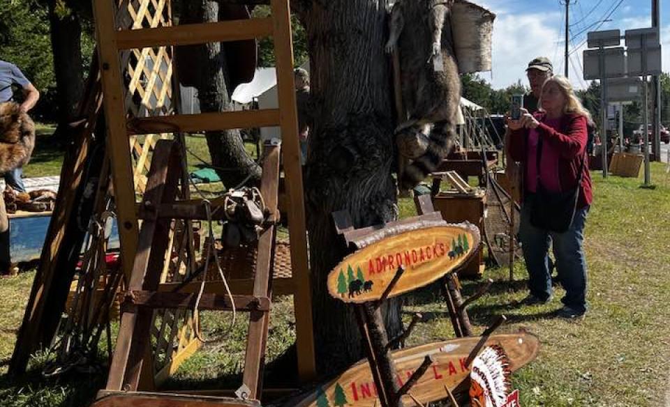 A variety of antiques on display with people browsing the items