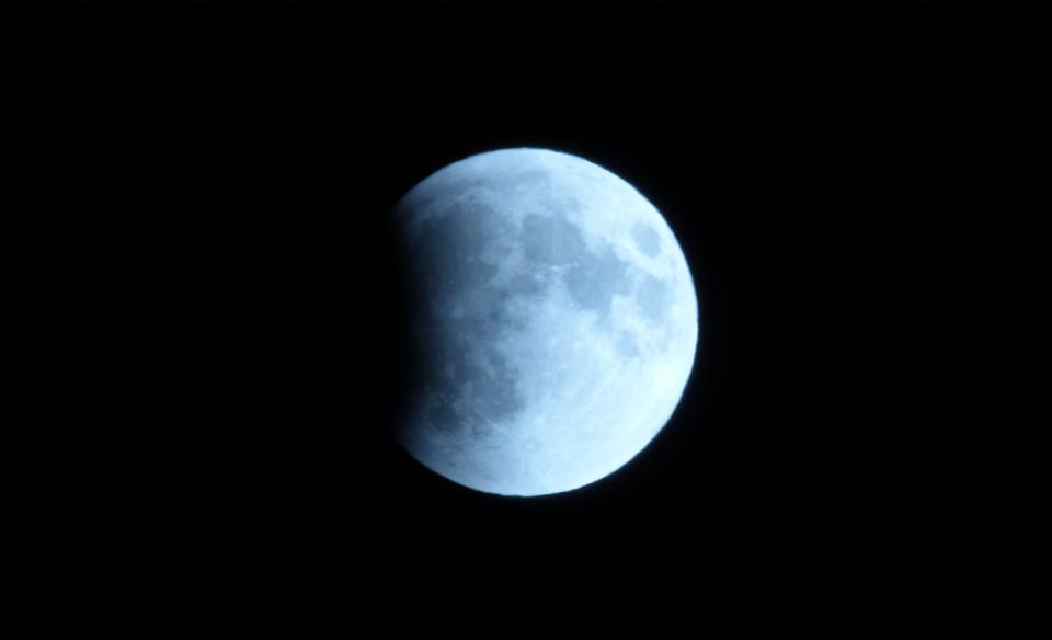 The moon up close, reflecting the sun's light with a black sky behind it