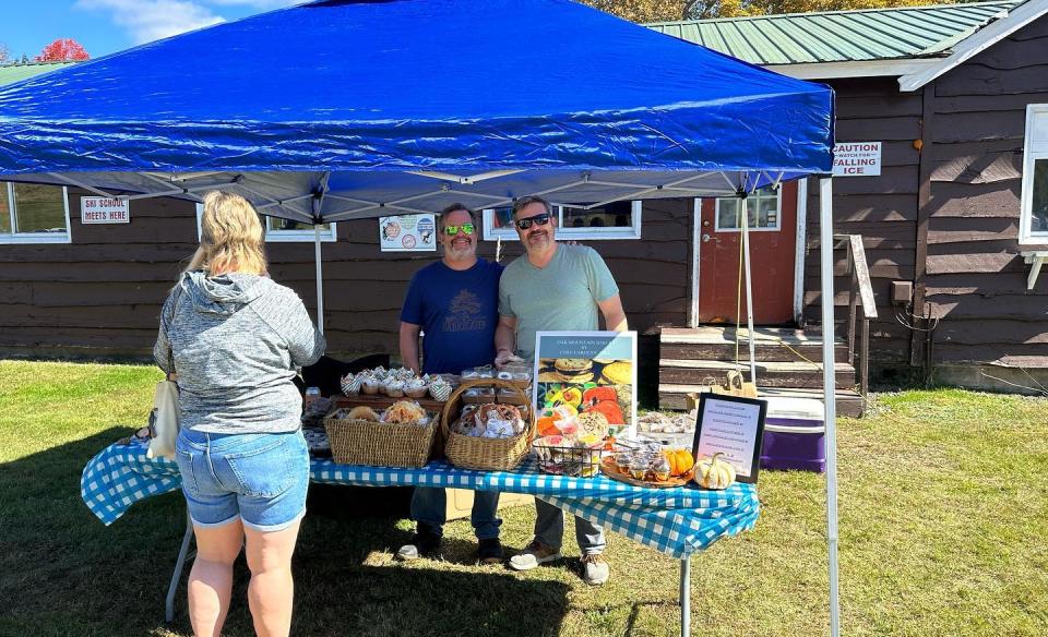 A person buying sweets at a vender tent selling baked goods