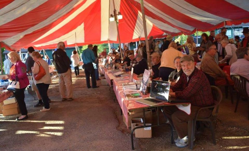 Photograph of people gathered under a large tent