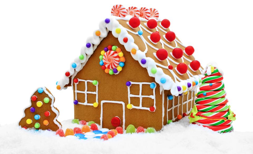 A gingerbread house decorated with white frosting and candies