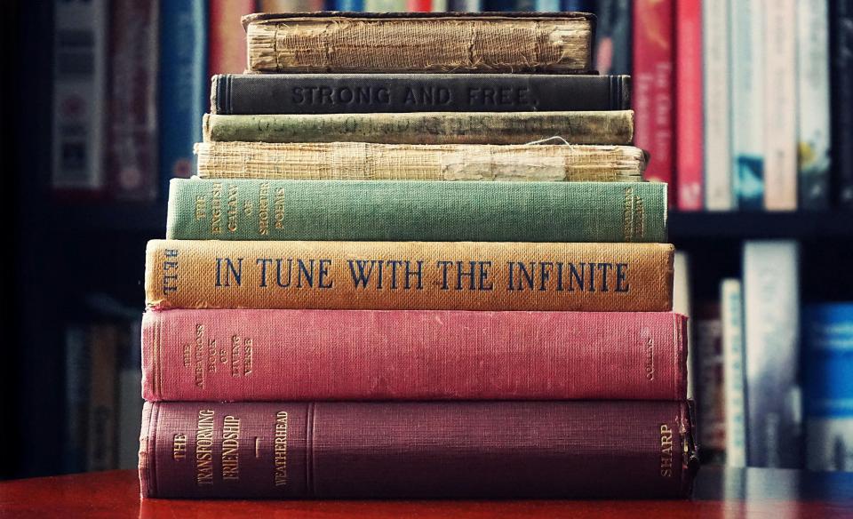 A stack of old, cloth covered books in a library