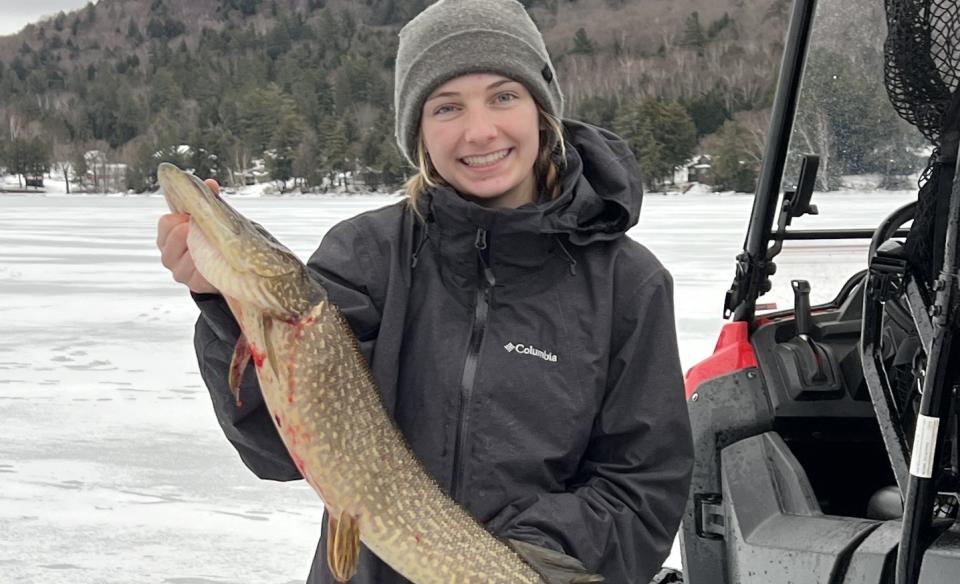 Woman holding a large fish she caught in fishing derby