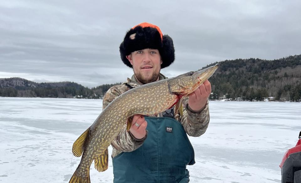 Man holding a large fish he caught at the fishing derby