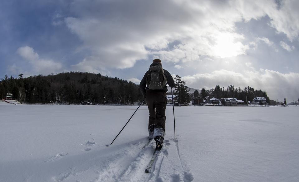 a person cross country skiing across the lake