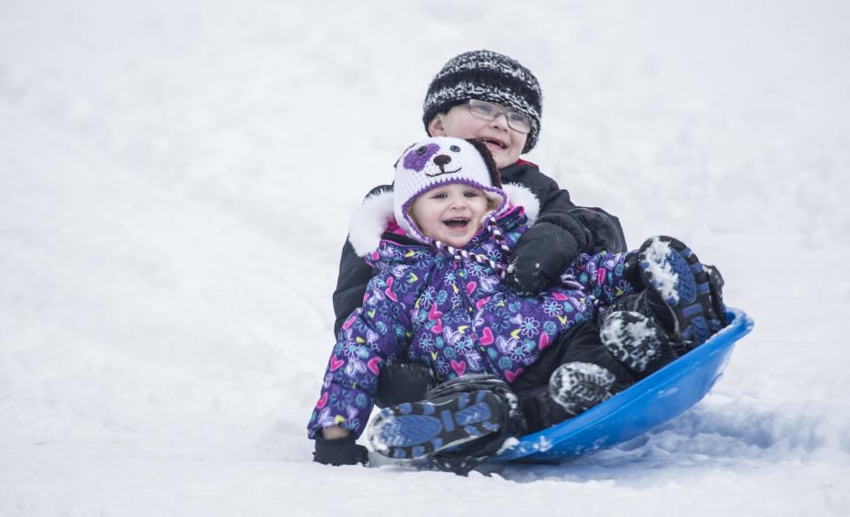 two kids sledding on one sled together