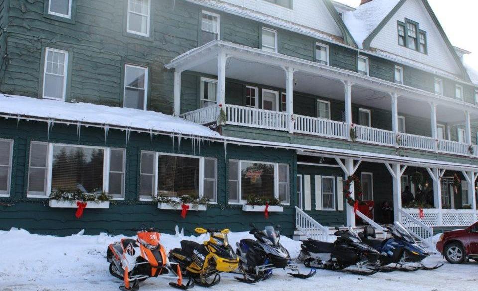 Adirondack Hotel with many snowmobiles parked outside