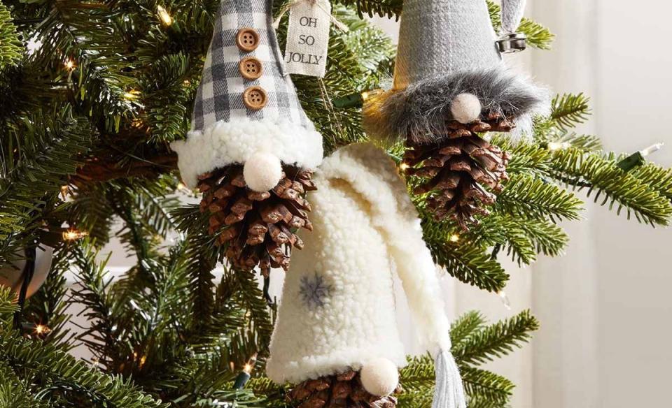 Pinecone gnome ornaments hanging from a christmas tree