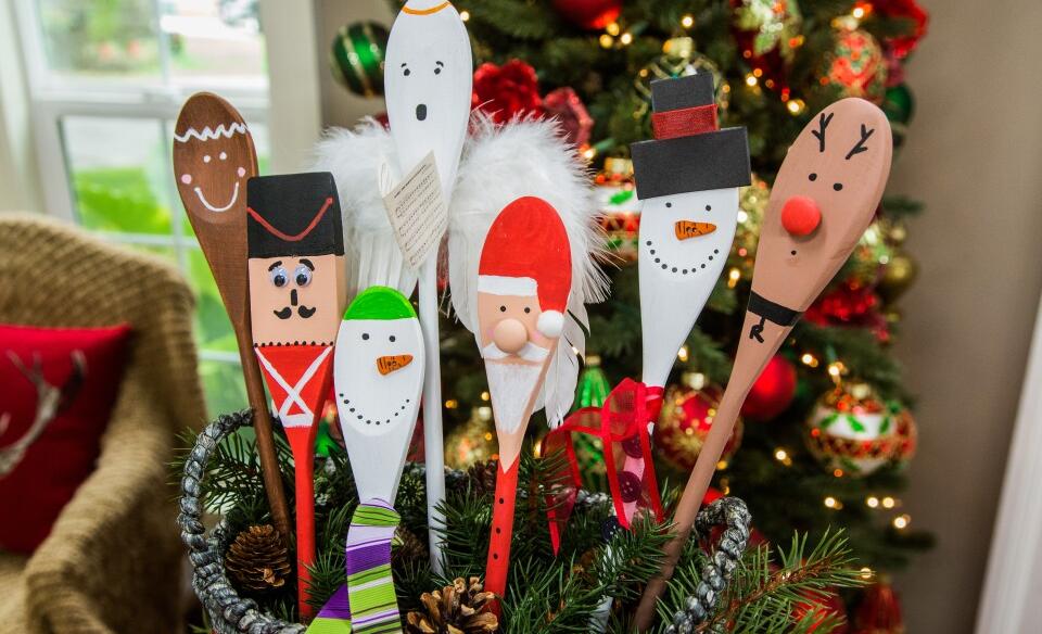 Several wooden spoons decorated and painted as different characters like a snowman, gingerbread man, reindeer, santa, and a nut cracker